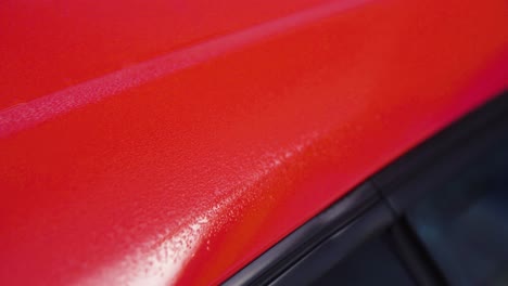 red car with wet paint job detail shot in slow motion