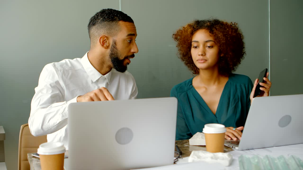 Architects discussing over laptop at desk 4k