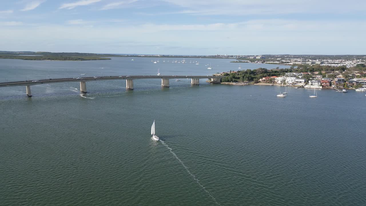 vista aérea alrededor de un velero, navegando frente al puente, mañana de verano en taren point, sydney