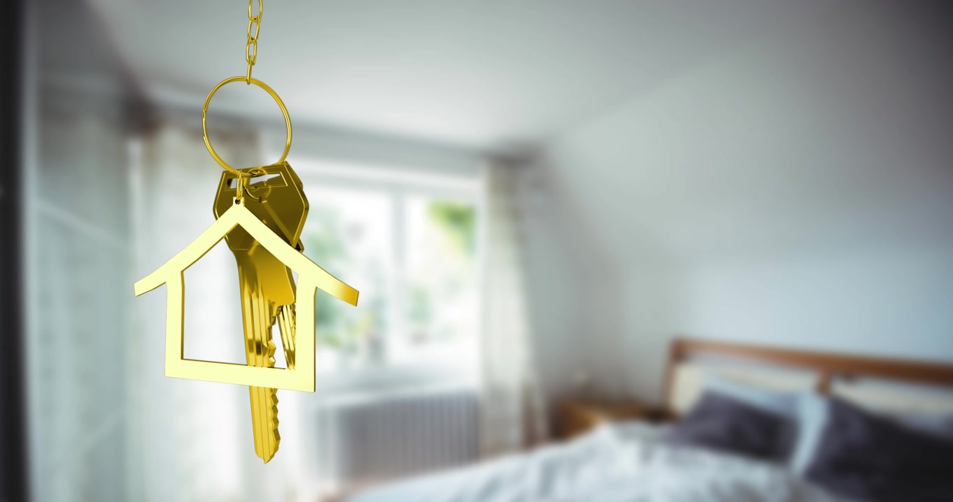 Portachiavi dorato a forma di casa appeso in una camera da letto sfocata