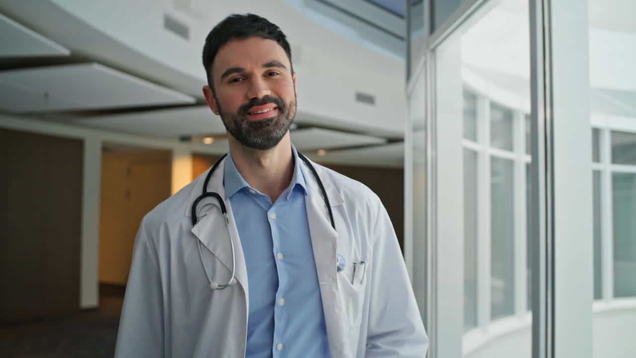 Confident doctor walking hallway with stethoscope. Closeup smiling man therapist