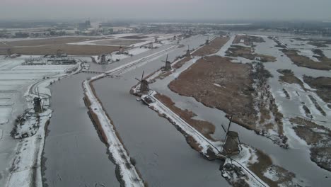 Above-famous-Kinderdijk-Windmills-during-winter,-white-snow-on-ground