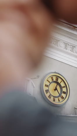 clock on old city tower through behind blurry kissing newlywed couple on street extreme closeup slow motion. loving man and woman. new family creation