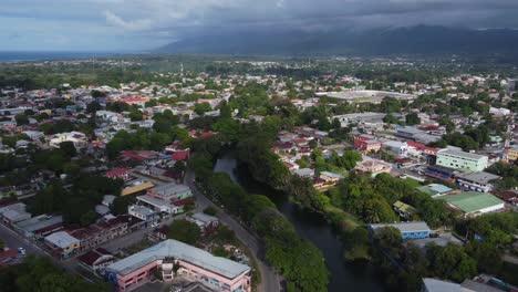 Tropical-river-runs-through-La-Ceiba,-Honduras-to-Caribbean-sea-coast