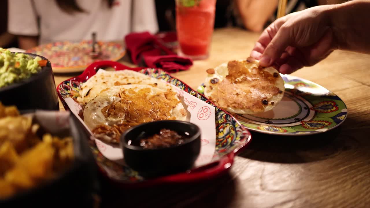 A vibrant dining scene in Bangkok with Tlayudas, showcasing colorful plates and warm lighting, capturing a lively atmosphere