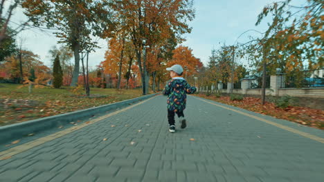 catching up with the toddler running by the park in autumn. grandpa follows his grandson with a toy.