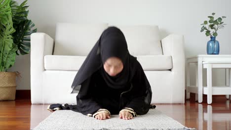 asian muslim woman praying and prostrating at home