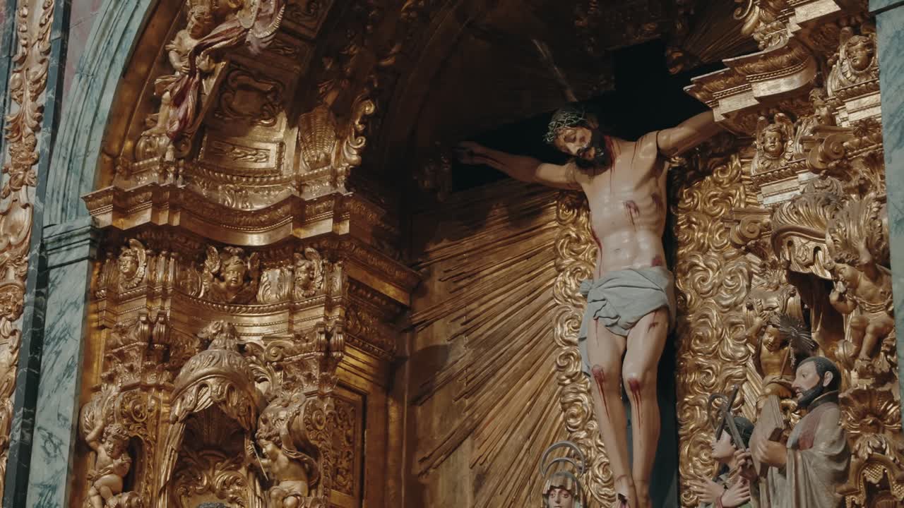 Statua del crocifisso di Gesù su un altare barocco dorato di una chiesa