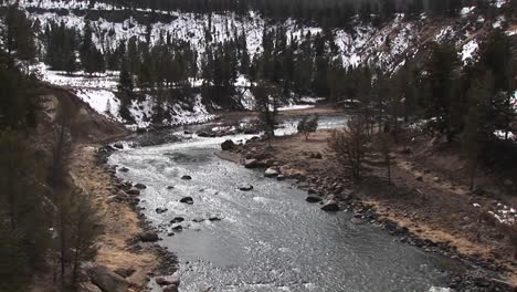 camera looks down on a picturesque mountain stream in winter