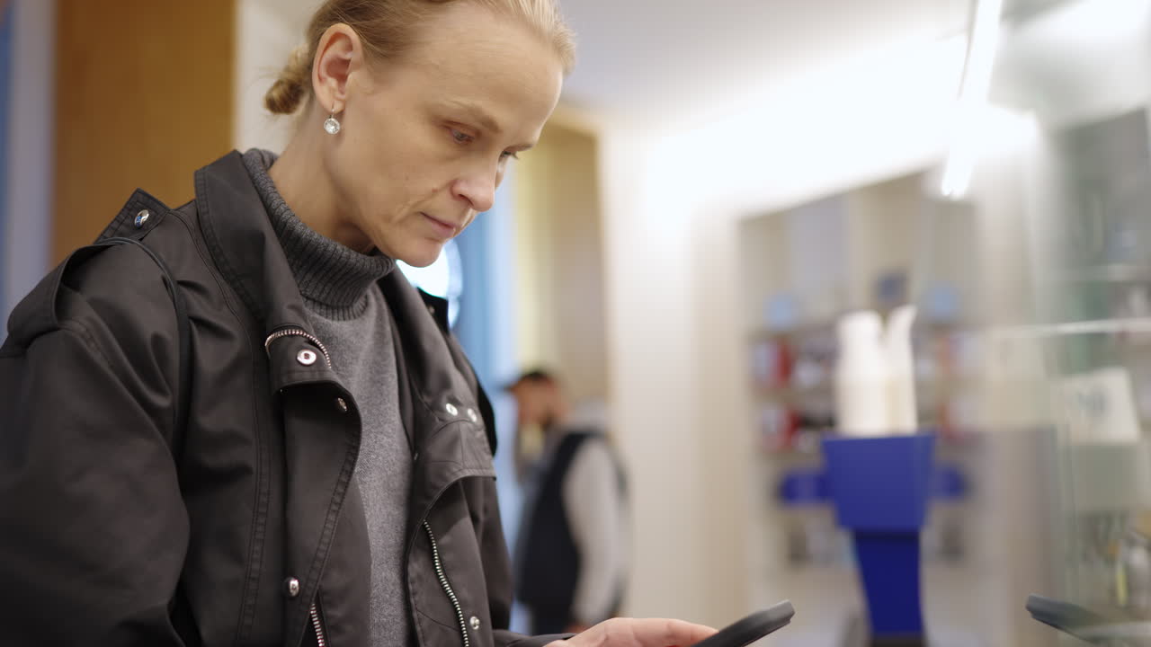 Woman Using Smartphone and Interacting with Screen in a Cafe
