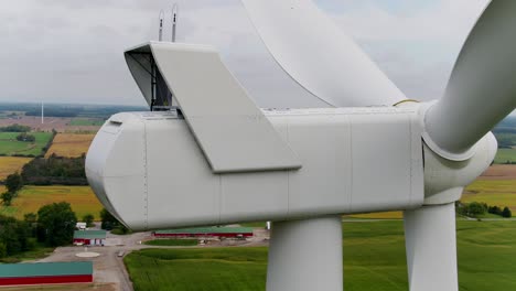 close up of wind turbine nacelle housing at the rear using a drone panning around the machine