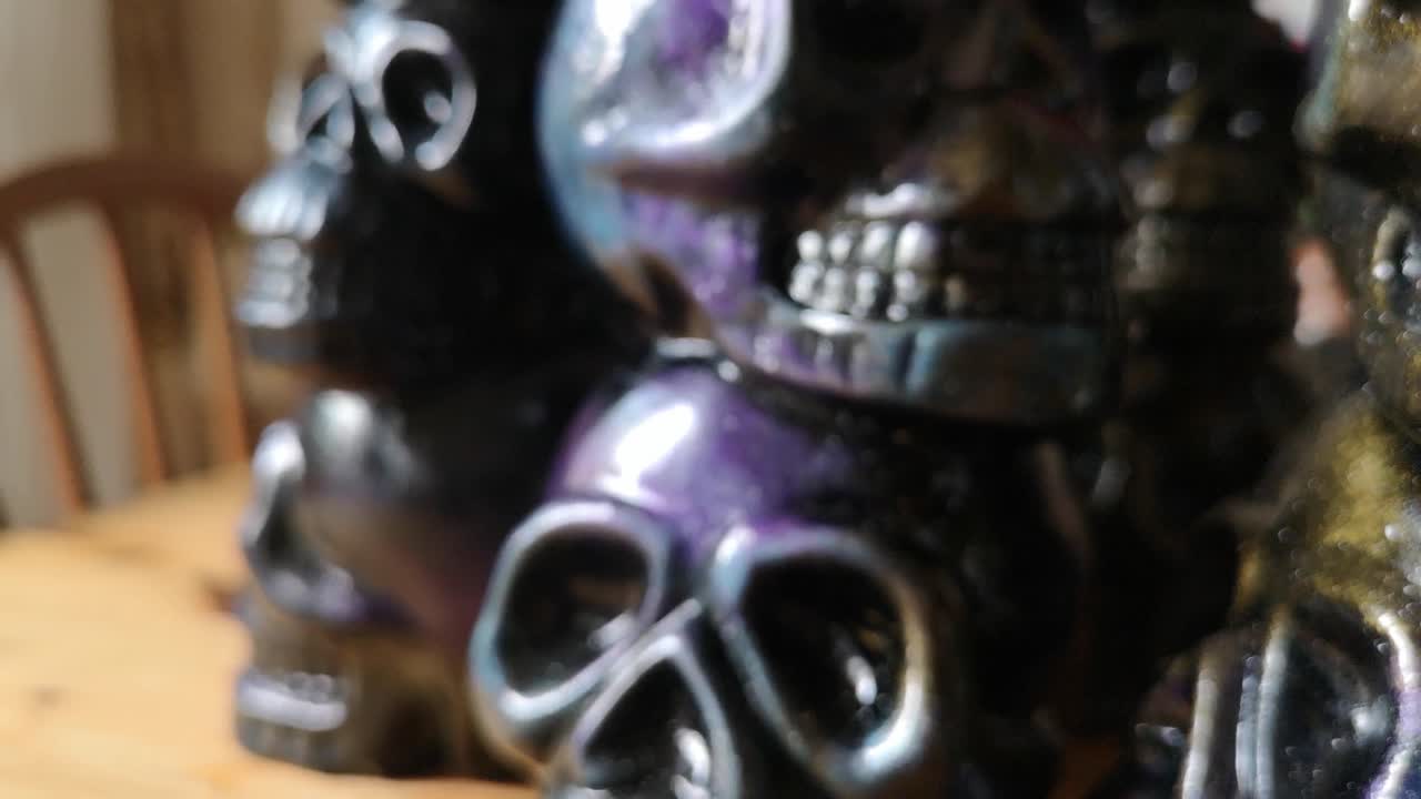 Colourful painted ceramic spooky death skull totem crafts pottery ornament shallow focus pull back