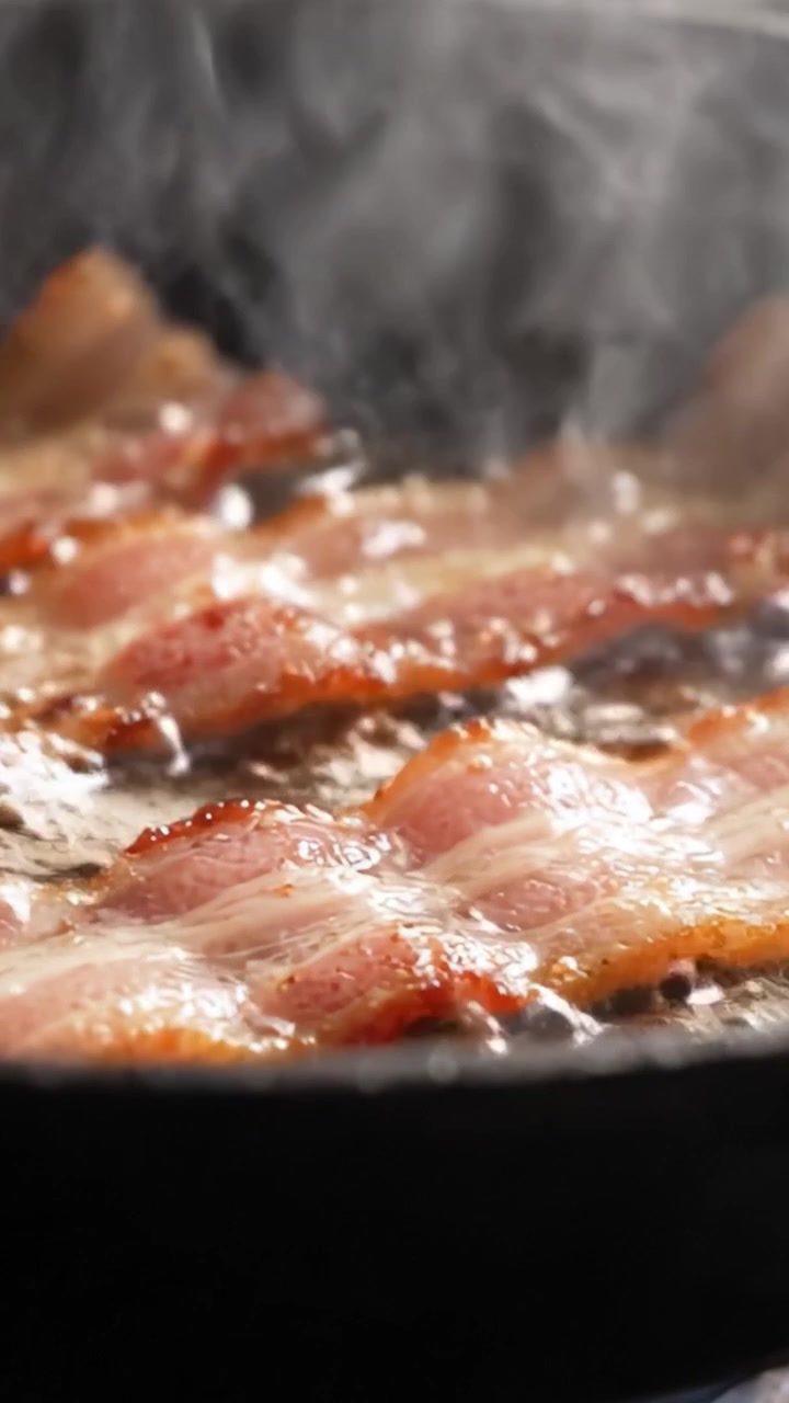 Pancetta Sfrigolante che Cuoce in Padella con il Suo Splendido Grasso e la Sua Consistenza, Perfettamente Catturata nell'Ultimo Fotogramma di Questa Deliziosa Esperienza Culinaria