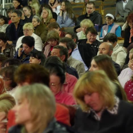 crowd of people to sitting and listening in a large hall