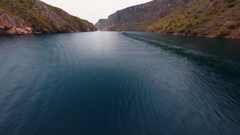 Aerial-View-Of-Ferry-Boat-Sailing-In-The-Euphrates-River-In-Halfeti,-Sanliurfa,-Turkey