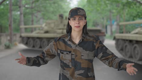 una mujer indígena enojada, oficial del ejército, gritando a alguien.