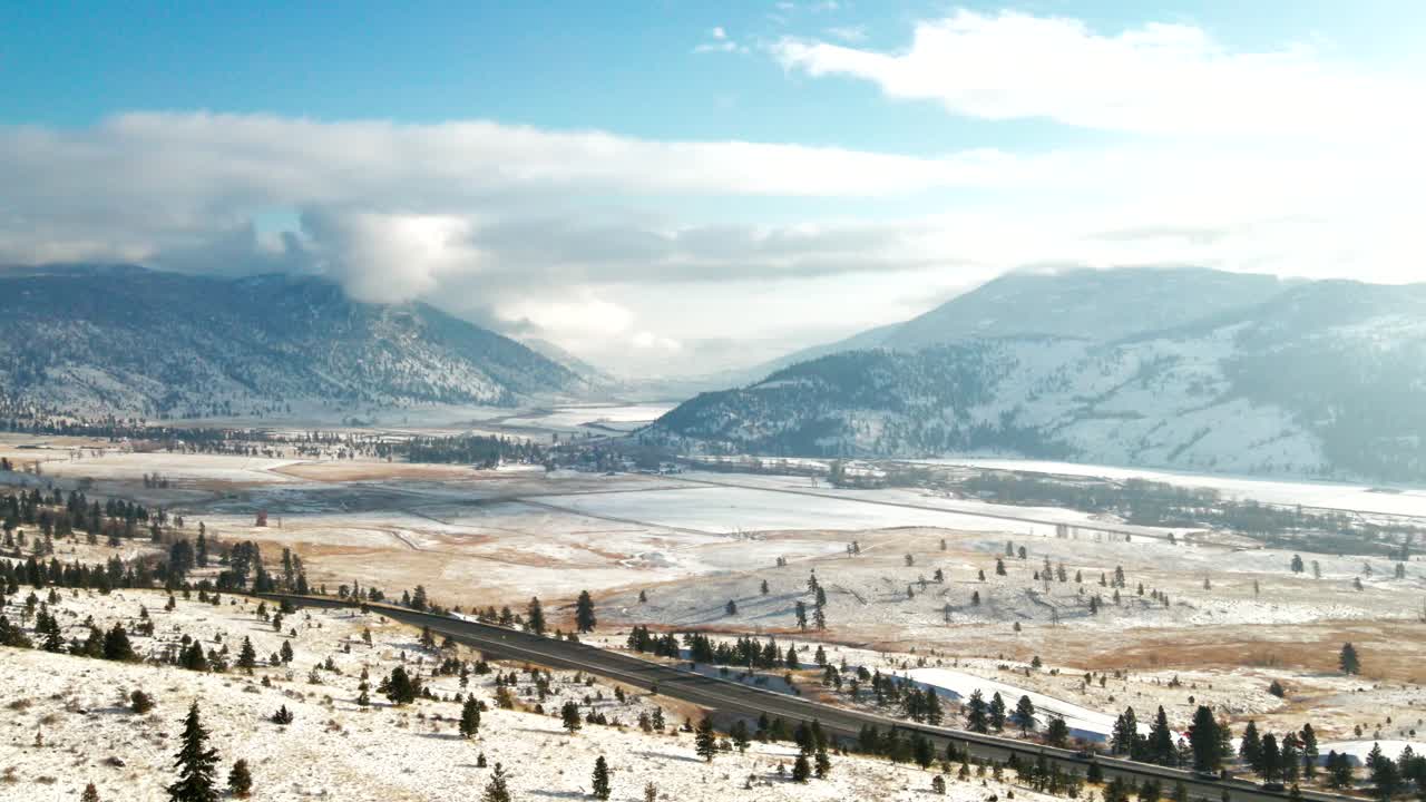 vista panorámica de la autopista 5a rodeada de praderas y montañas del valle de nicola cubiertas de nieve ligera en un día parcialmente nublado en invierno con sol en merritt, bc canadá