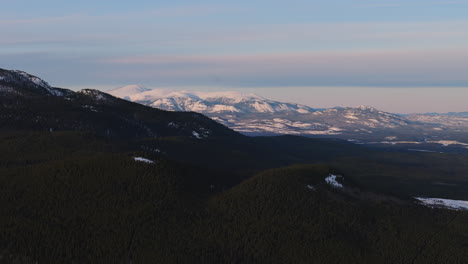 stunning aerial view of fish lake’s frozen expanse surrounded by snow-covered mountains near whitehorse, yukon. a pristine winter landscape showcasing the beauty of canada’s wilderness