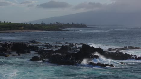 aerial slo-mo pan of rocky coast by ho’okipa at north shore of maui