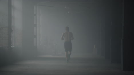 Muscular-man-doing-cardio-workout-in-loft-building.-Guy-running-in-corridor