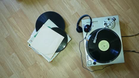 old vinyl records and turntable on the wooden surface top down view