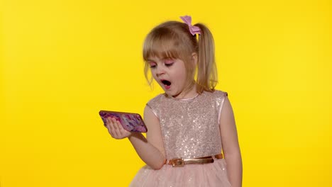 child girl using smartphone. kid looking at the screen of a mobile phone, watching cartoons
