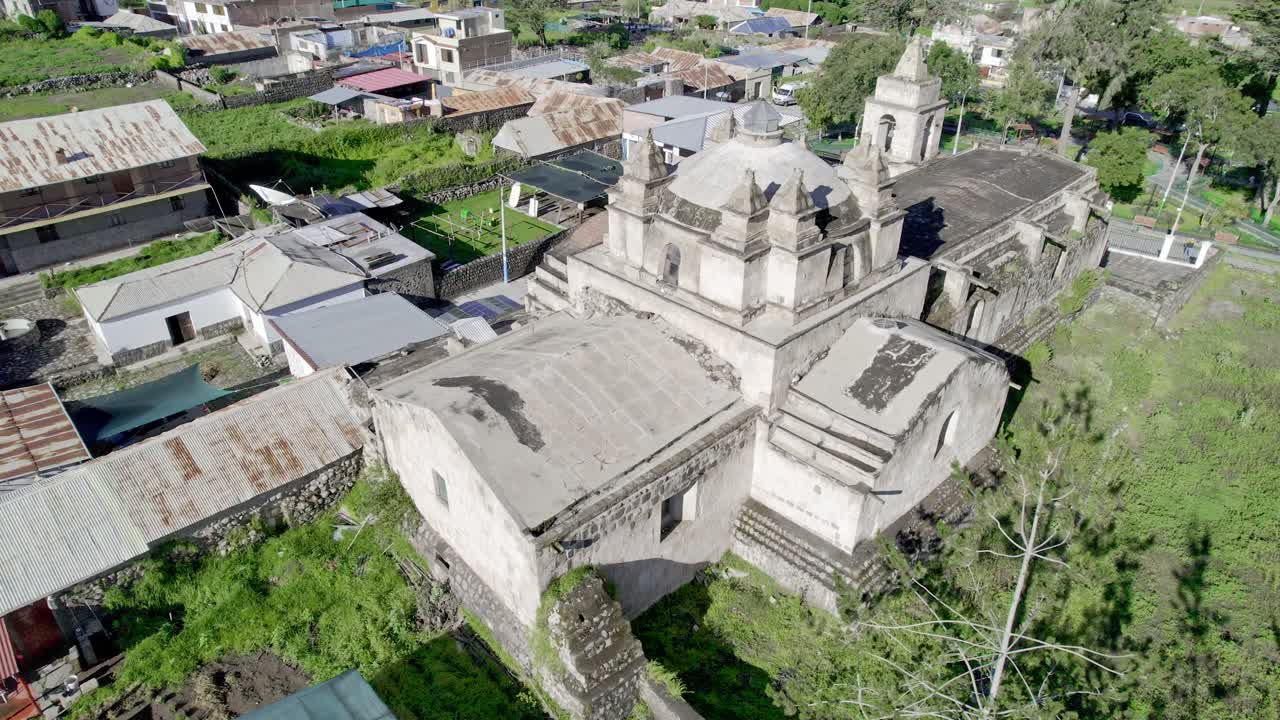 Aerial shot showcasing the back of the Chiguata Church, with tourists admiring its stunning architecture in the heart of Arequipa.