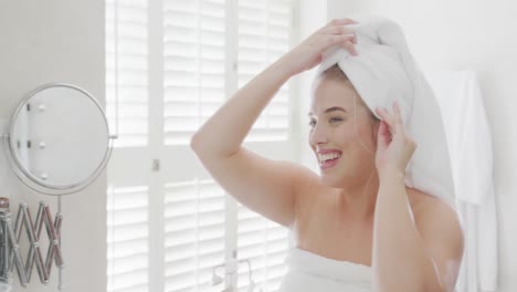 happy caucasian plus size woman in front of mirror with towel on head in slow motion