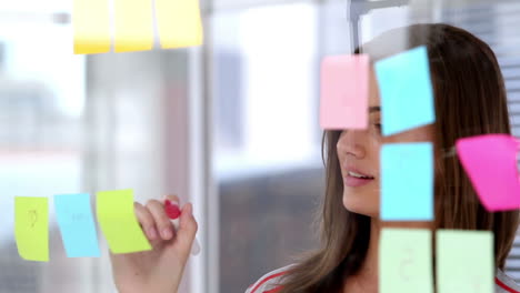 woman writing on sticky note