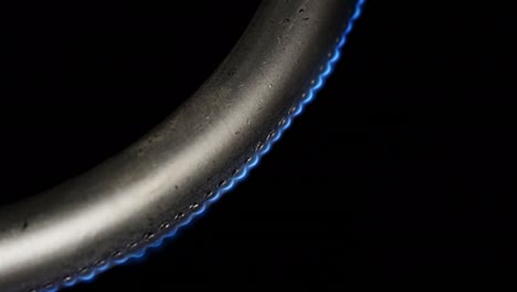 Burning gas burner in the oven close-up on a black background with a slowly fading flame. 4k macro raw video.