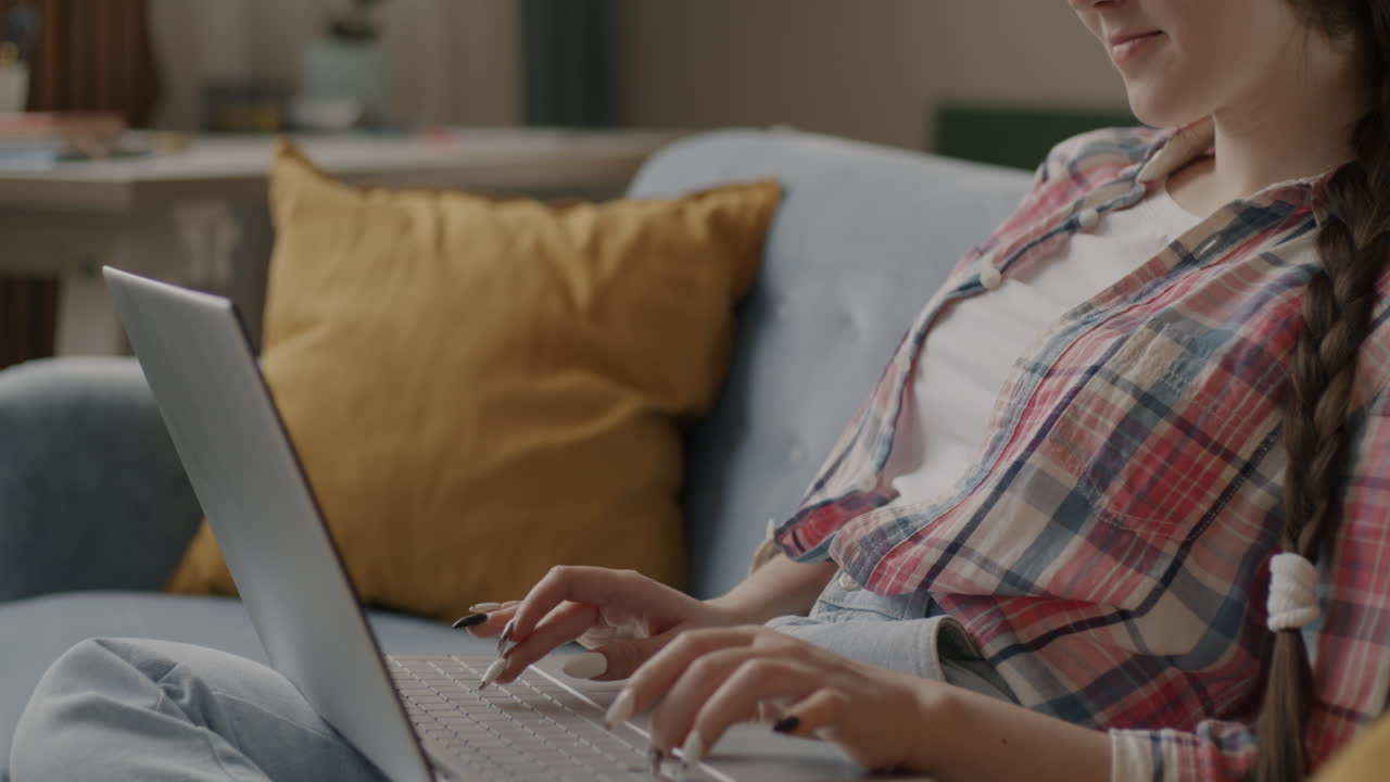 mujer joven trabajando en una computadora portátil en casa