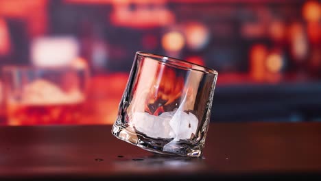 leeres und eiskaltes whiskey-glas auf einem dunklen tisch