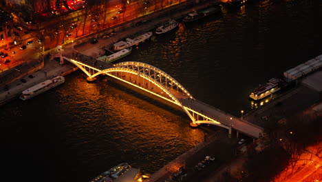 Cityscape-view-from-above-of-the-Pont-Alexandre-III-bridge-over-the-Seine-river-in-Paris,-illuminated-at-night,-France