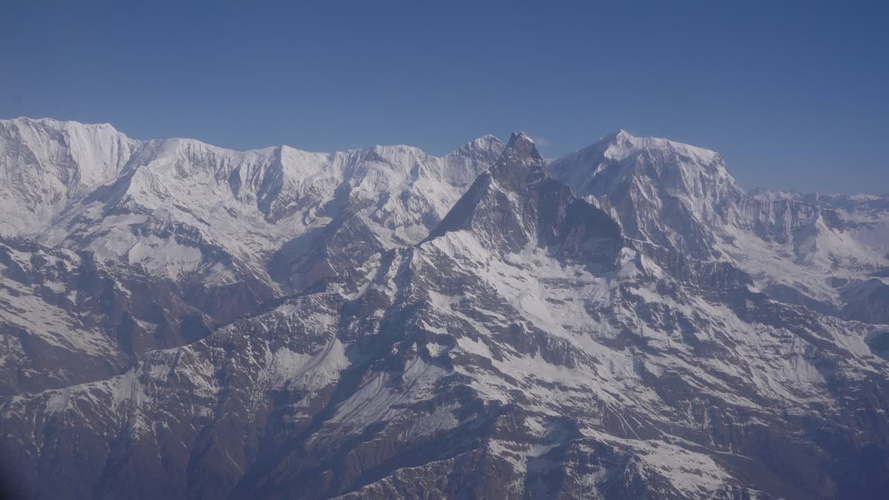 Wide panoramic view of the Himalayan range in Nepal captured from a mountain flight, showcasing snow-covered summits
