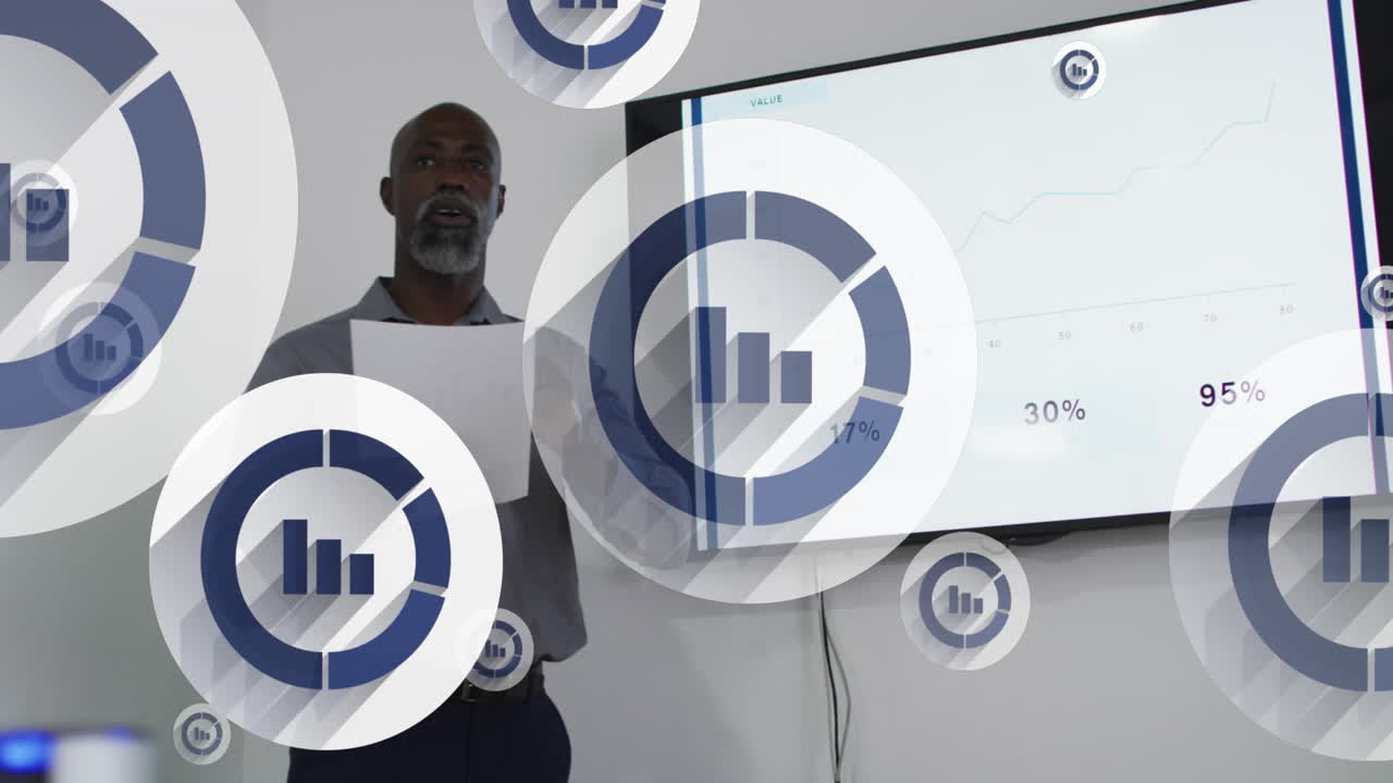 Animation of bar graph icons floating against african american man giving a presentation at office
