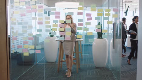 hermosa mujer de negocios usando un teléfono inteligente tomando fotos de notas adhesivas orgullosa de la resolución exitosa de problemas ideas de estrategia con mapa mental creativo trabajando en la oficina 4k