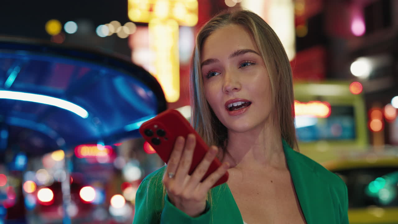 Woman using phone at night in the city