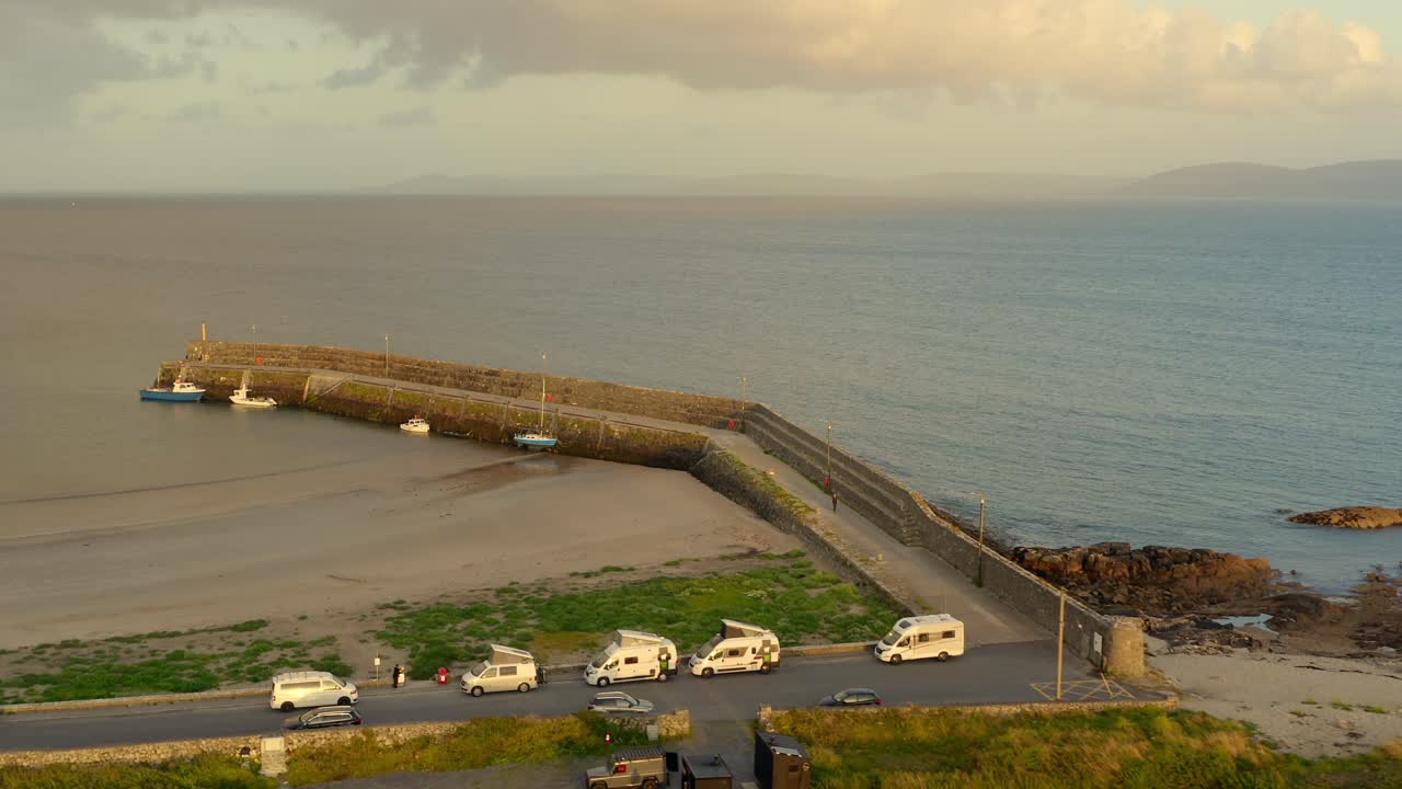fotografía aérea dinámica del muelle de spiddal y la playa al atardecer