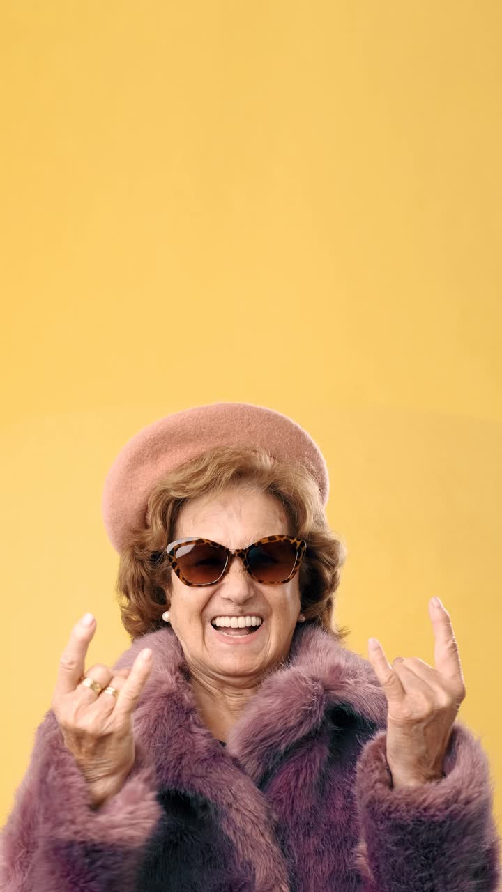 Stylish Senior Woman Making Rock On Hand Gesture