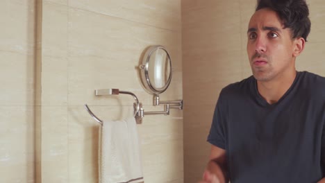 angry young man argues with himself in front of a mirror
