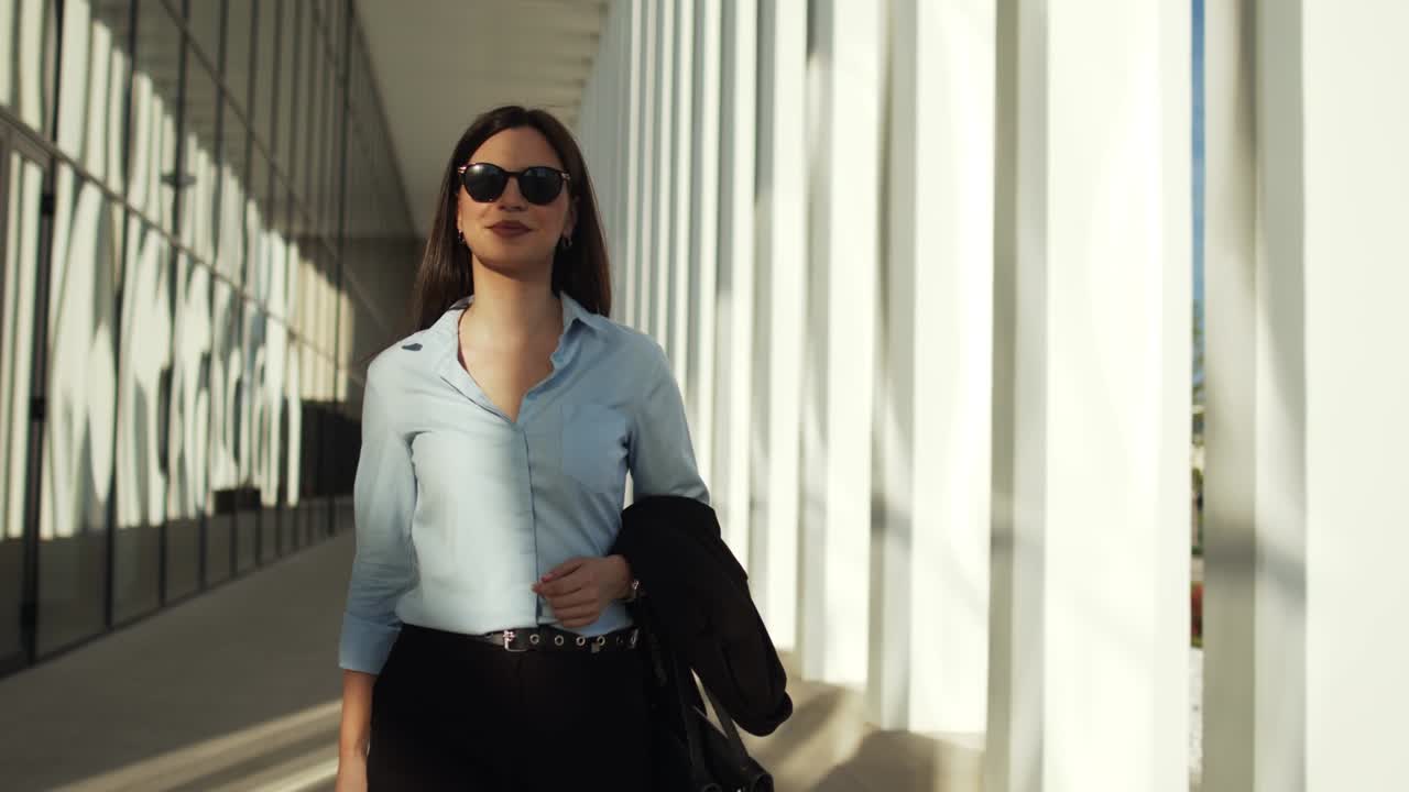 Business woman walking outdoors in front of office building
