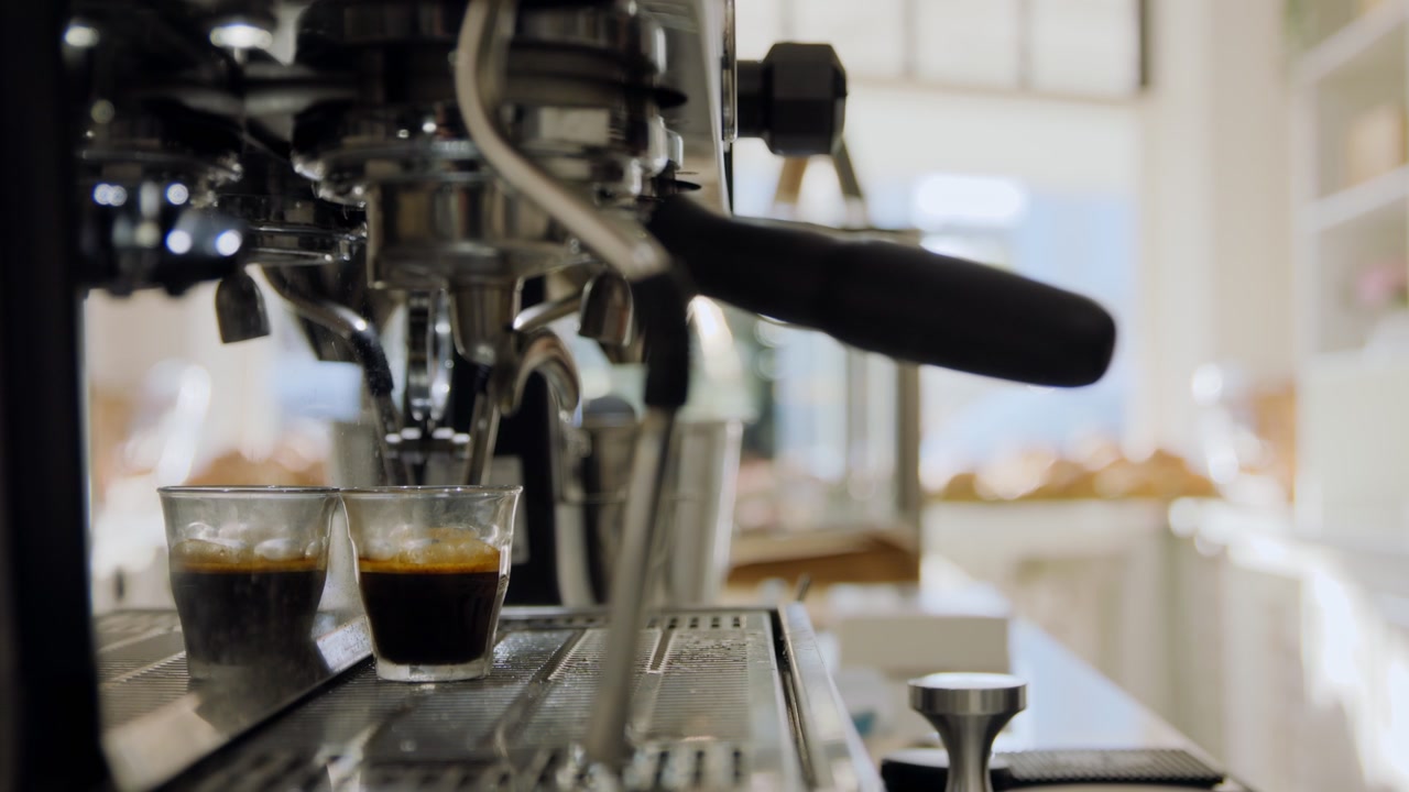 Un barista che lavora in un caffè mentre prepara un caffè espresso