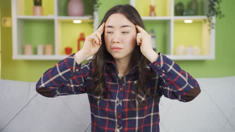 편두통을  ⁇ 고 있는 아시아 젊은 여성.