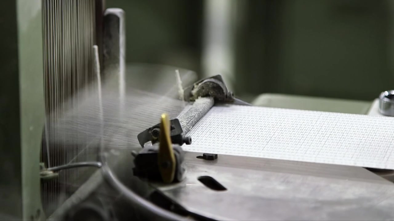 最新の製造施設内で技術的な医療用生地を織る自動化された工業用織機のクローズアップ。ヘルスケア用途向けの高速繊維生産プロセス