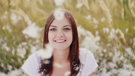 Portrait-Of-A-Young-Woman-Looks-At-The-Camera-Before-Her-And-On-Her-Down-And-Down-Feathers