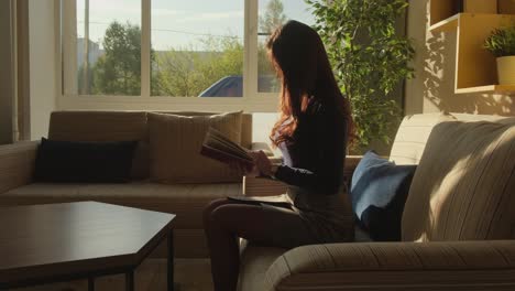 mujer leyendo un libro en un sofá
