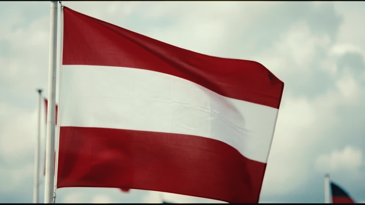 Bandiera austriaca che sventola al vento contro un cielo nuvoloso
