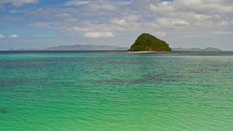 couple on inflatable boat in tropical turquoise waters near island