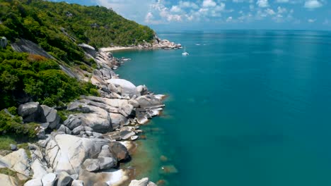 flying over amazing rocky beach and tropical lagoon with yacht