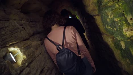 gente caminando explorando un largo y profundo túnel subterráneo de piedra, alcantarillas romanas en medina, cádiz, españa